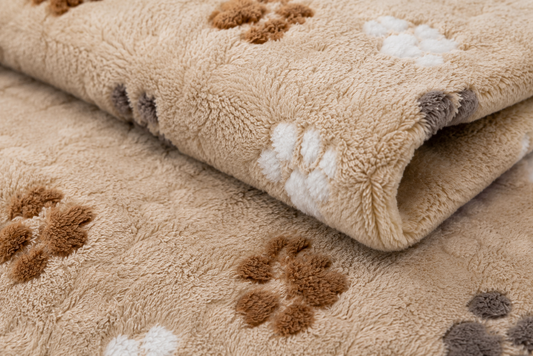 Close-up of a soft, plush beige rug with a playful paw print pattern in brown
