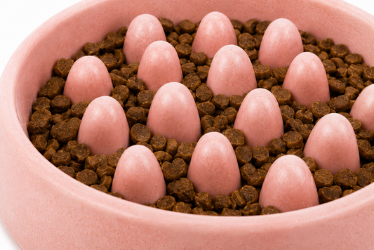 Pink bowl filled with chocolate-covered candies and round pink truffles