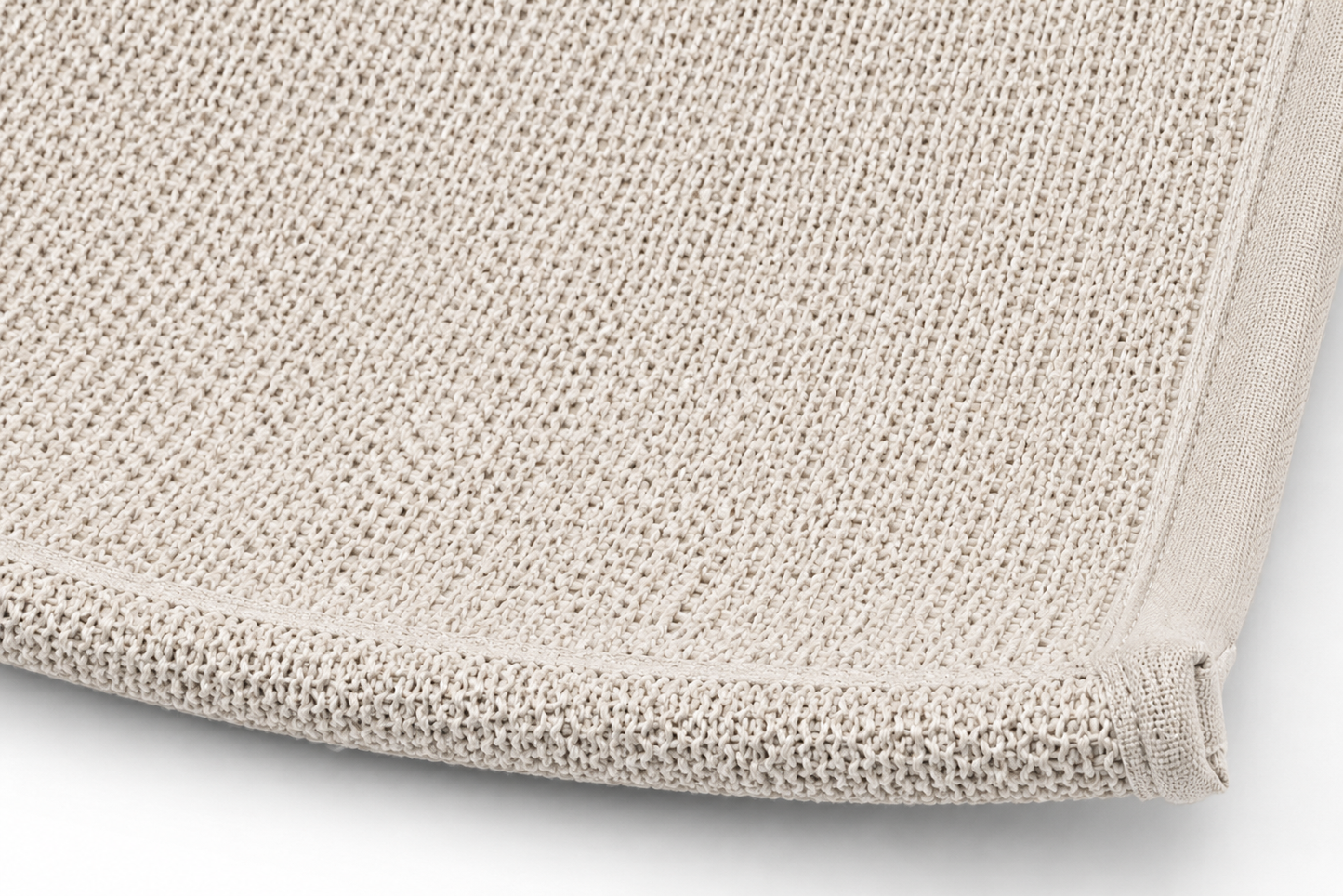 Close-up view of a neatly folded, light beige, textured bath towel edge