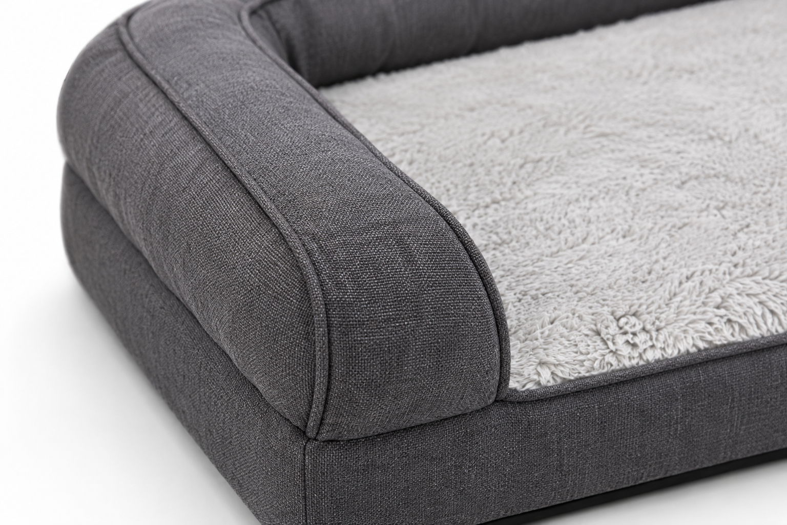 Close-up of a plush, gray dog bed with bolstered sides and soft fabric texture