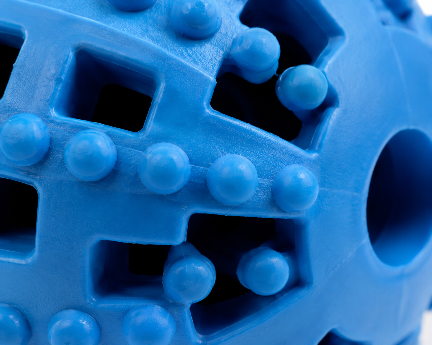 Close-up view of a textured blue plastic toy ball with various shapes and bumps
